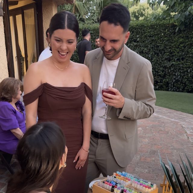 Invitados sonriendo junto al puesto de ilustración en directo de DELUNA en una boda