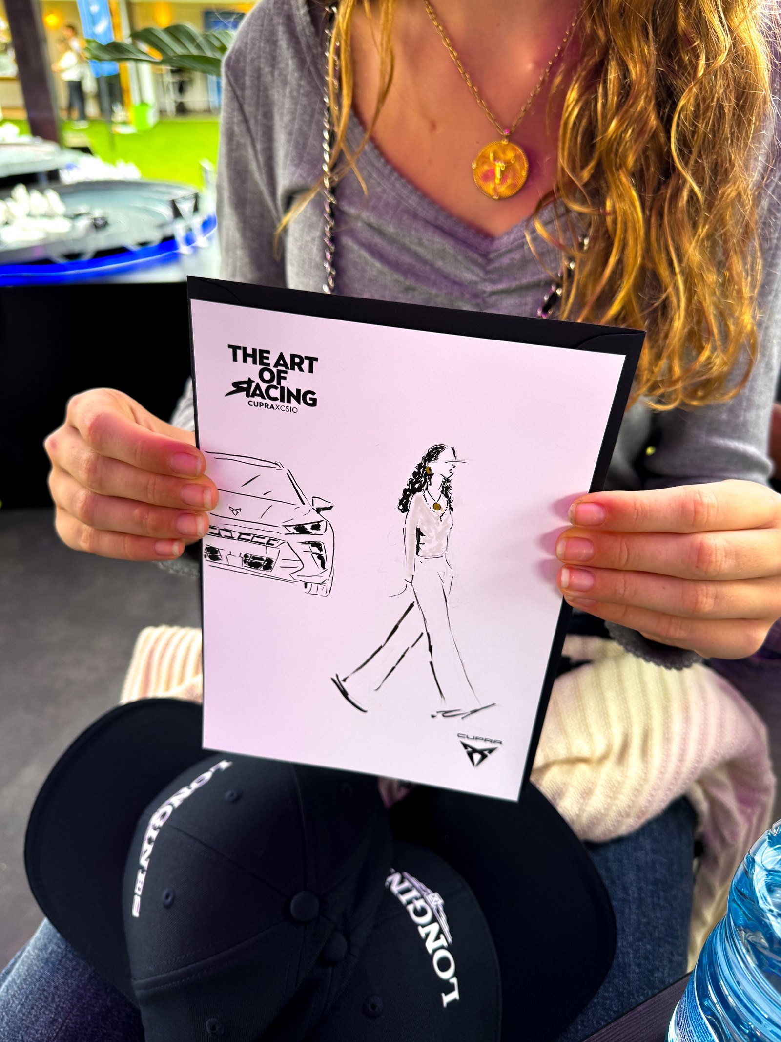 Asistente mostrando su ilustración personalizada junto al espacio de CUPRA